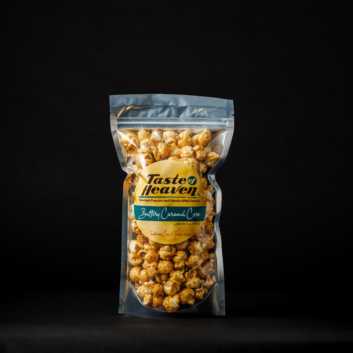 A clear stand-up pouch of Taste of Heaven Buttery Caramel Popcorn on a solid black background.
