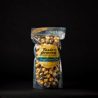 A clear stand-up pouch of Taste of Heaven Drizzled Caramel Corn, standing upright against a solid black background.