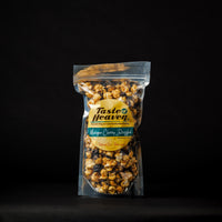 A clear stand-up pouch of Tasted Heaven Michigan Cherry Drizzled bag filled with popcorn, set against a solid black background.